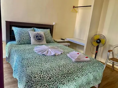 a bedroom with a bed with two towels on it at Pensão Twins Carioca in Tarrafal