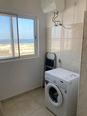 a laundry room with a washing machine and a window at My Boavista 3 in Sal Rei