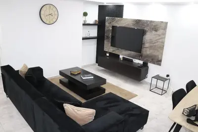 a living room with a black couch and a tv at Micaya in Praia