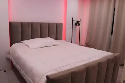 a large bed in a room with pink lighting at Micaya in Praia