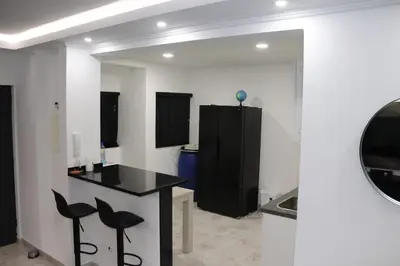 a kitchen with a black counter and black stools at Micaya in Praia