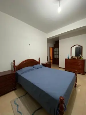 a bedroom with a large blue bed and a mirror at Mindelo Family Apartment in Mindelo