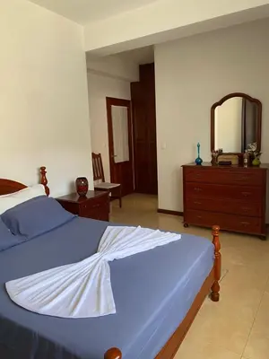 a bedroom with a bed and a dresser and a mirror at Mindelo Family Apartment in Mindelo