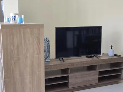 a flat screen tv on a wooden entertainment center at Diva Apartamento in Praia