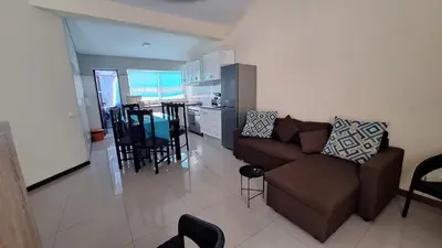 a living room with a couch and a kitchen at Diva Apartamento in Praia