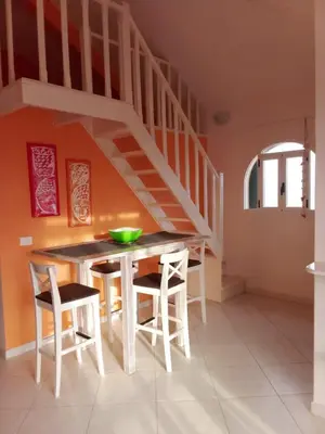 a kitchen with a table and chairs and a staircase at Holiday Properties Vista Do Mar - Wi-fi in Santa Maria