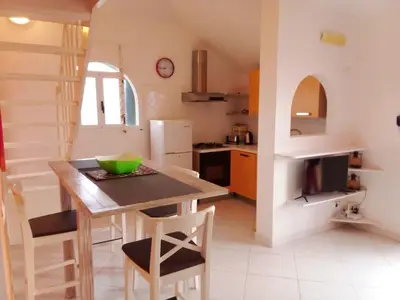 a kitchen with a table and chairs in a room at Holiday Properties Vista Do Mar - Wi-fi in Santa Maria