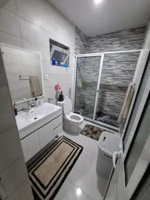 a white bathroom with a toilet and a sink at One-bedroom apartment rental - Chã de Alecrim - SV in Mindelo