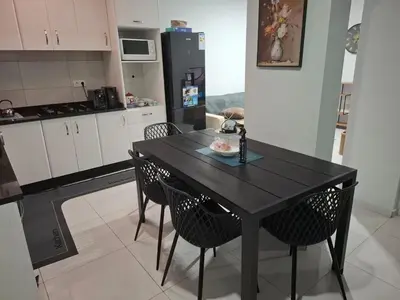 a kitchen with a black table and two chairs at One-bedroom apartment rental - Chã de Alecrim - SV in Mindelo