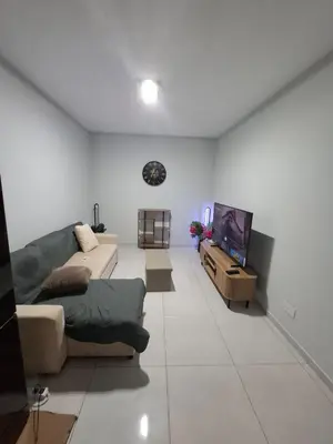 a living room with a couch and a flat screen tv at One-bedroom apartment rental - Chã de Alecrim - SV in Mindelo