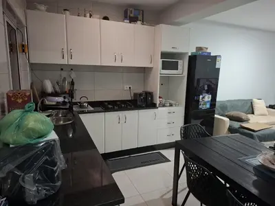 a kitchen with white cabinets and a black counter top at One-bedroom apartment rental - Chã de Alecrim - SV in Mindelo