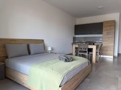 a bedroom with a large bed and a kitchen at Praça Presidente - By Bobbywashere in Santa Maria