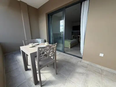 a table and chair in a room with a bedroom at Praça Presidente - By Bobbywashere in Santa Maria