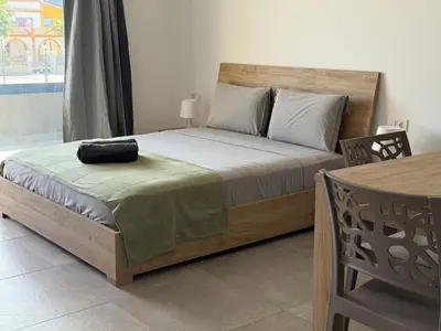 a bedroom with a bed with a wooden headboard and a table at Praça Presidente - By Bobbywashere in Santa Maria