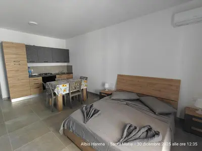 a bedroom with a large bed and a kitchen at Studio Apartment in the Center in Santa Maria