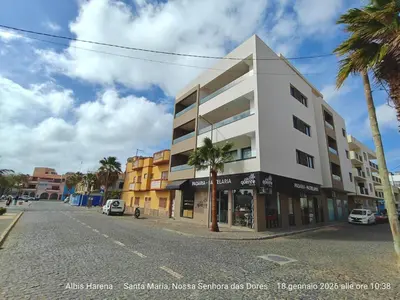 a building on the side of a street with palm trees at Studio Apartment in the Center in Santa Maria