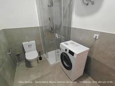 a bathroom with a shower and a washing machine at Studio Apartment in the Center in Santa Maria