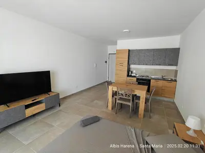 a living room with a television and a table with chairs at Studio Apartment in the Center in Santa Maria