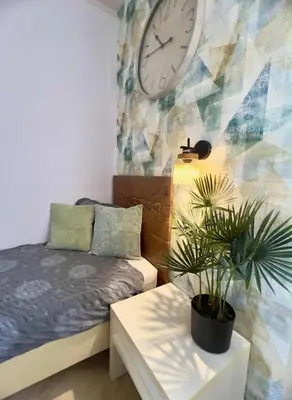 a bedroom with a bed and a clock on the wall at Tropical Palma in Santa Maria