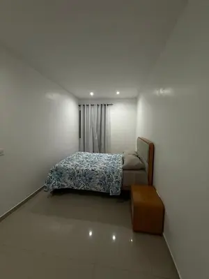 a small bedroom with a bed and a table at Morabeza Home in Praia