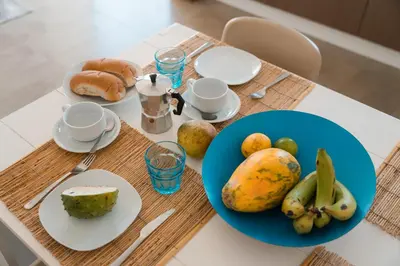 a table with a blue plate of fruit on it at Las Rochas Mindelo Aparthotel in Mindelo