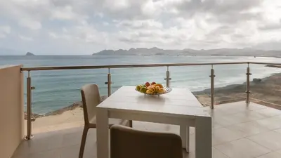 a table with a bowl of fruit on a balcony at Las Rochas Mindelo Aparthotel in Mindelo