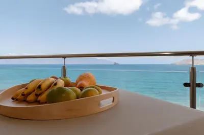 a bowl of fruit on a table in front of a window at Las Rochas Mindelo Aparthotel in Mindelo
