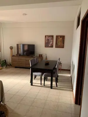 a dining room with a table and chairs and a television at Shay's House in Mindelo in Mindelo