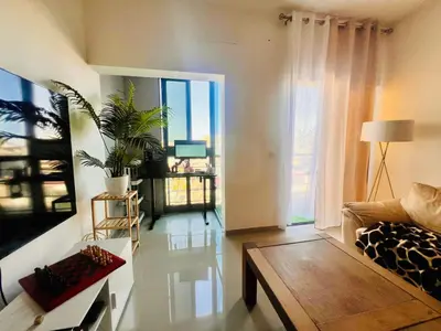 a living room with a couch and a table at Shared Room with Balcony in Praia 5 Minute Walk to Beach in Praia