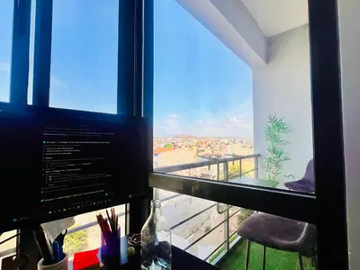a computer monitor sitting on a desk in front of a window at Shared Room with Balcony in Praia 5 Minute Walk to Beach in Praia