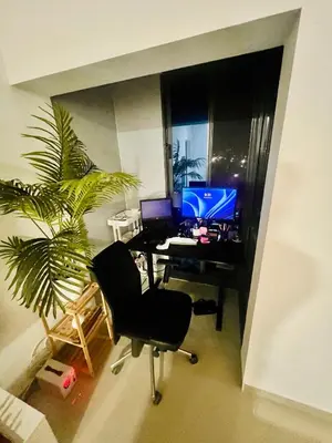 an office with a desk with a computer and a palm tree at Shared Room with Balcony in Praia 5 Minute Walk to Beach in Praia