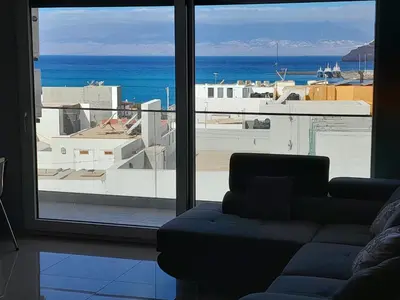 a living room with a couch and a view of the ocean at VISTA INVEST Apartamentos in Mindelo