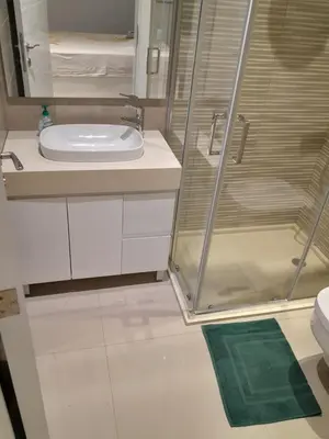 a bathroom with a sink and a glass shower at VISTA INVEST Apartamentos in Mindelo
