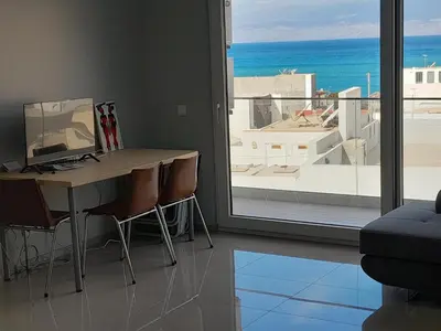 a room with a desk and a view of the ocean at VISTA INVEST Apartamentos in Mindelo