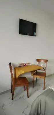 a wooden table and a chair and a tv on a wall at Studio Sol e Sal in Santa Maria
