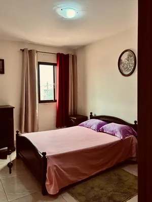 a bedroom with a bed and a clock on the wall at Ferreira e Brito apartamentos in Espargos