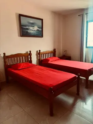 two beds in a room with red sheets at Ferreira e Brito apartamentos in Espargos