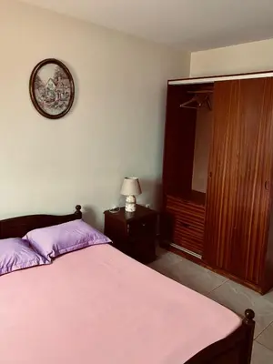 a bedroom with a bed and a clock on the wall at Ferreira e Brito apartamentos in Espargos