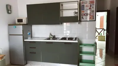 a kitchen with green cabinets and a white refrigerator at Verdes Anos - local accommodation in Santa Maria in Santa Maria