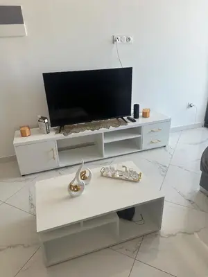 a white living room with a tv and a table at Bestview of Palmarejo in Praia