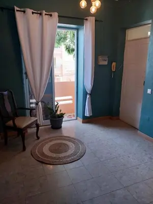 a room with a door and a chair and a window at Sol, Terra e Mar- No coração do Plateau in Praia