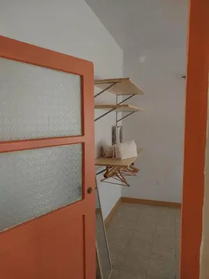 a room with a door and a kitchen with a shelf at Sol, Terra e Mar- No coração do Plateau in Praia