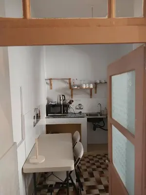 a small kitchen with a white table and a counter at Sol, Terra e Mar- No coração do Plateau in Praia