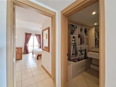 a bedroom with a door leading into a room with a bed at 1 bedroom apartment in Vila Verde Resort in Santa Maria