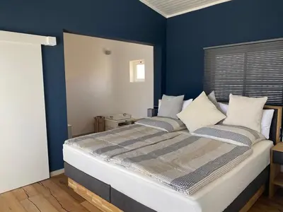 a bedroom with a large bed with blue walls at Penthouse Lieblingsplatz - Favorite place frontline in Sal Rei