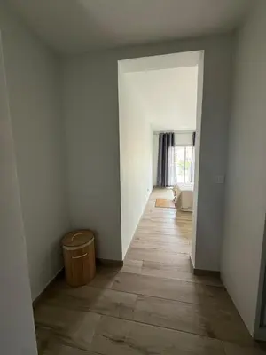 an empty room with a hallway with a wooden floor at Spacious apartment in Praia Great for families in Montagarro