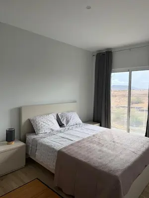 a white bedroom with a bed and a window at Spacious apartment in Praia Great for families in Montagarro