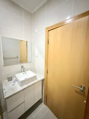 a bathroom with a sink and a wooden door at Spacious apartment in Praia Great for families in Montagarro