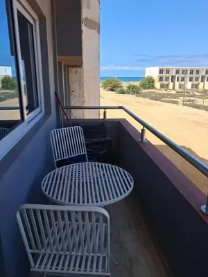 a table and chairs on a balcony with a beach at T1 Cá Djana in Sal Rei