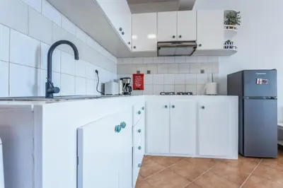 a kitchen with white cabinets and a refrigerator at Casa do Sal - AC, Free Wi-Fi, Near Beach in Santa Maria